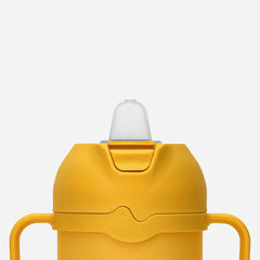 Comotomo tumbler handle detail highlighting self-orienting grip for easier toddler holding