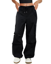COPYLEAF front view of black cargo pants showing baggy silhouette and pockets benefit: versatile styling