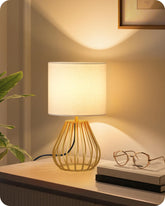 GOEBLESON front view of gold table lamp showing elegant shape and warm ambiance