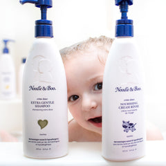 Noodle & Boo bottle placed by a bathtub demonstrating everyday bath routine convenience