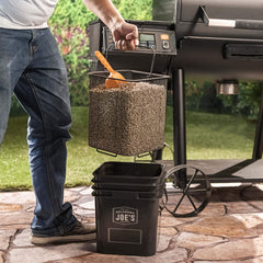 Oklahoma Joe's pellet bucket in use with scoop transferring pellets efficiently