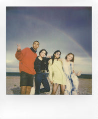 Polaroid film ejecting from camera demonstrating instant print emergence and excitement