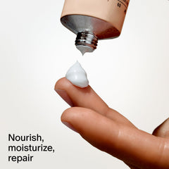 Salt & Stone tube next to phone illustrating 2 fl oz travel-friendly size