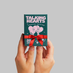 Hand holding Talking Hearts cards to show scale, brand proves portable convenience