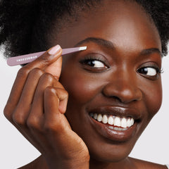 Tweezerman slant tweezer Purple Wisteria in hand demonstrating compact scale and comfortable control