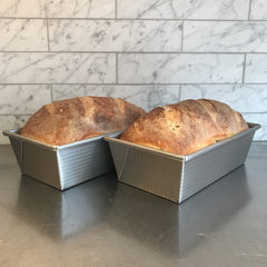 USA Pan loaf pan held by hand to show scale and ease of handling