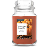 Yankee Candle front jar showing spiced pumpkin scent and warm amber glow benefit