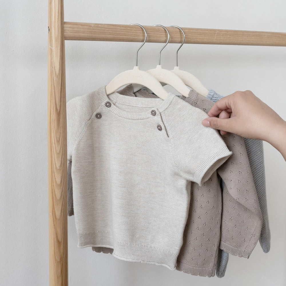 3 Sprouts hanger beside baby shirt for scale, shows child-size fit benefit