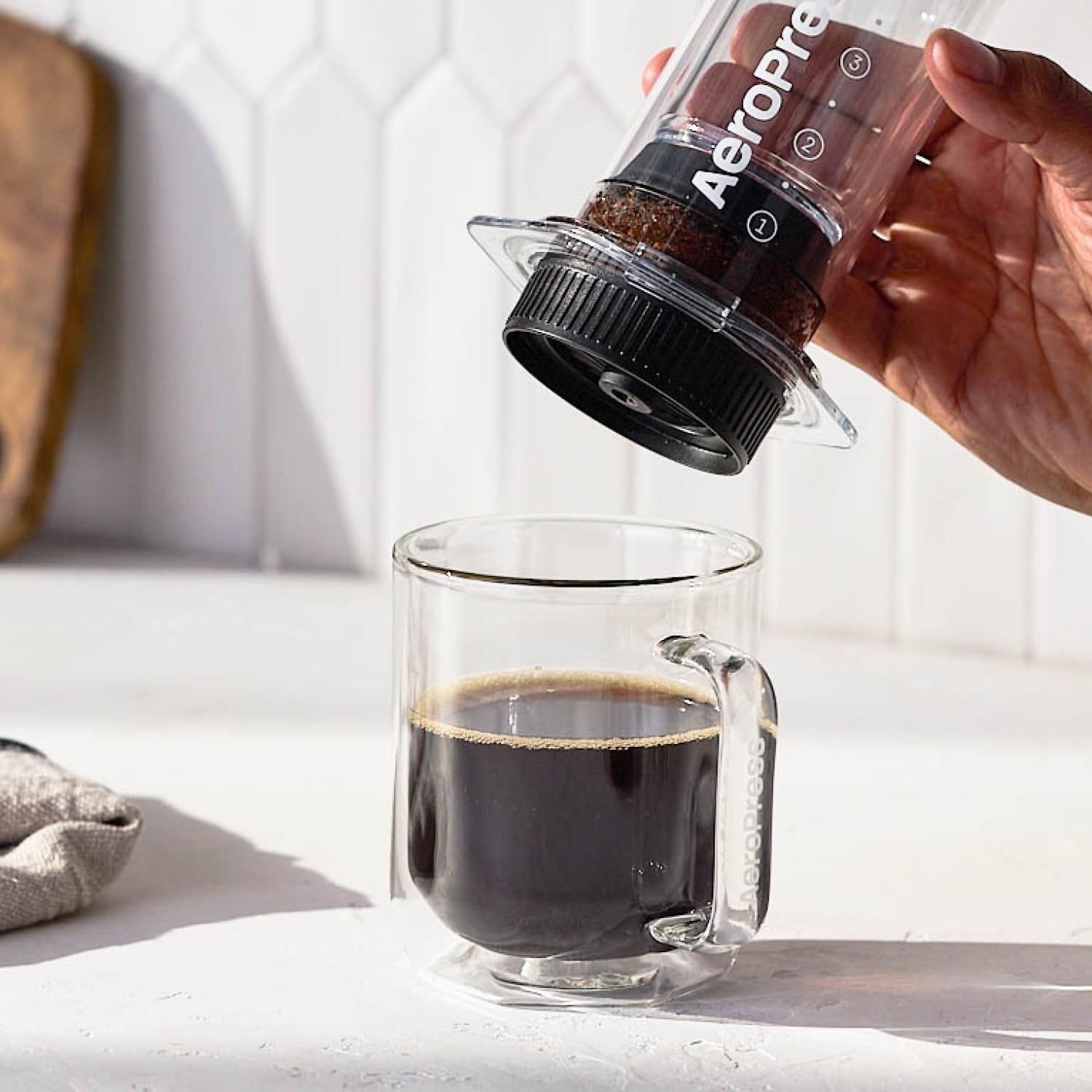 AeroPress cap beside a scale to show compact size and portability