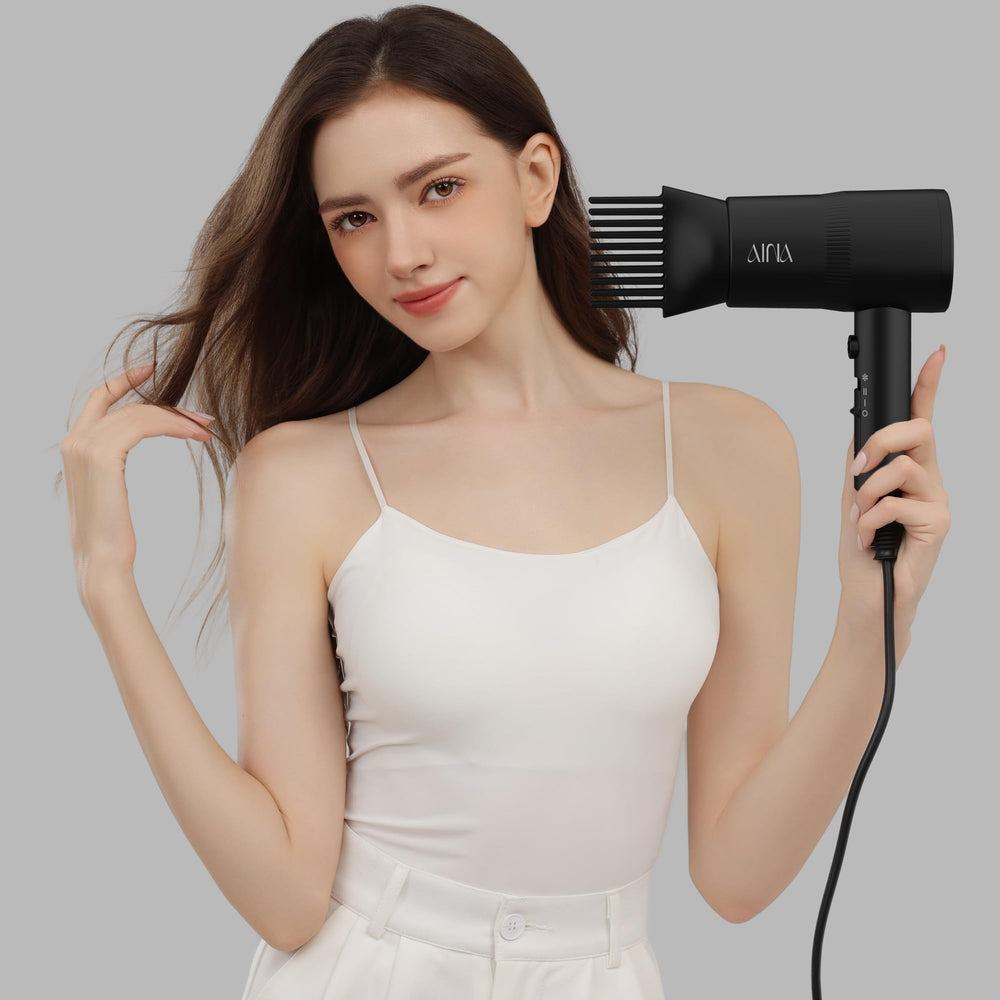 AINA in-use styling on woman with wavy hair, creates smoother frizz-reduced finish