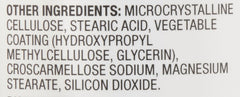 Amazon Basics bottle on a kitchen counter next to a glass of water illustrating convenient daily supplement use