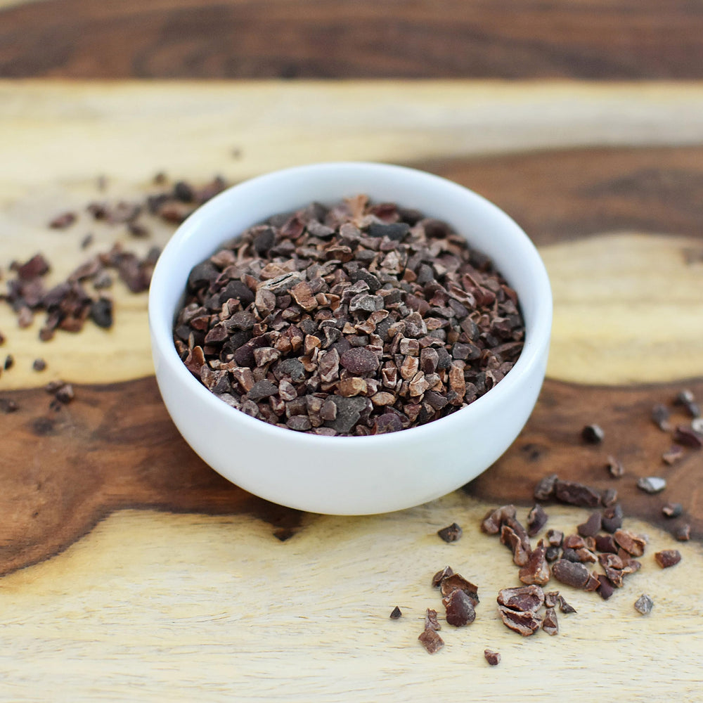 Bowl of Anthony's cacao nibs with a spoon ready to use for recipes benefit