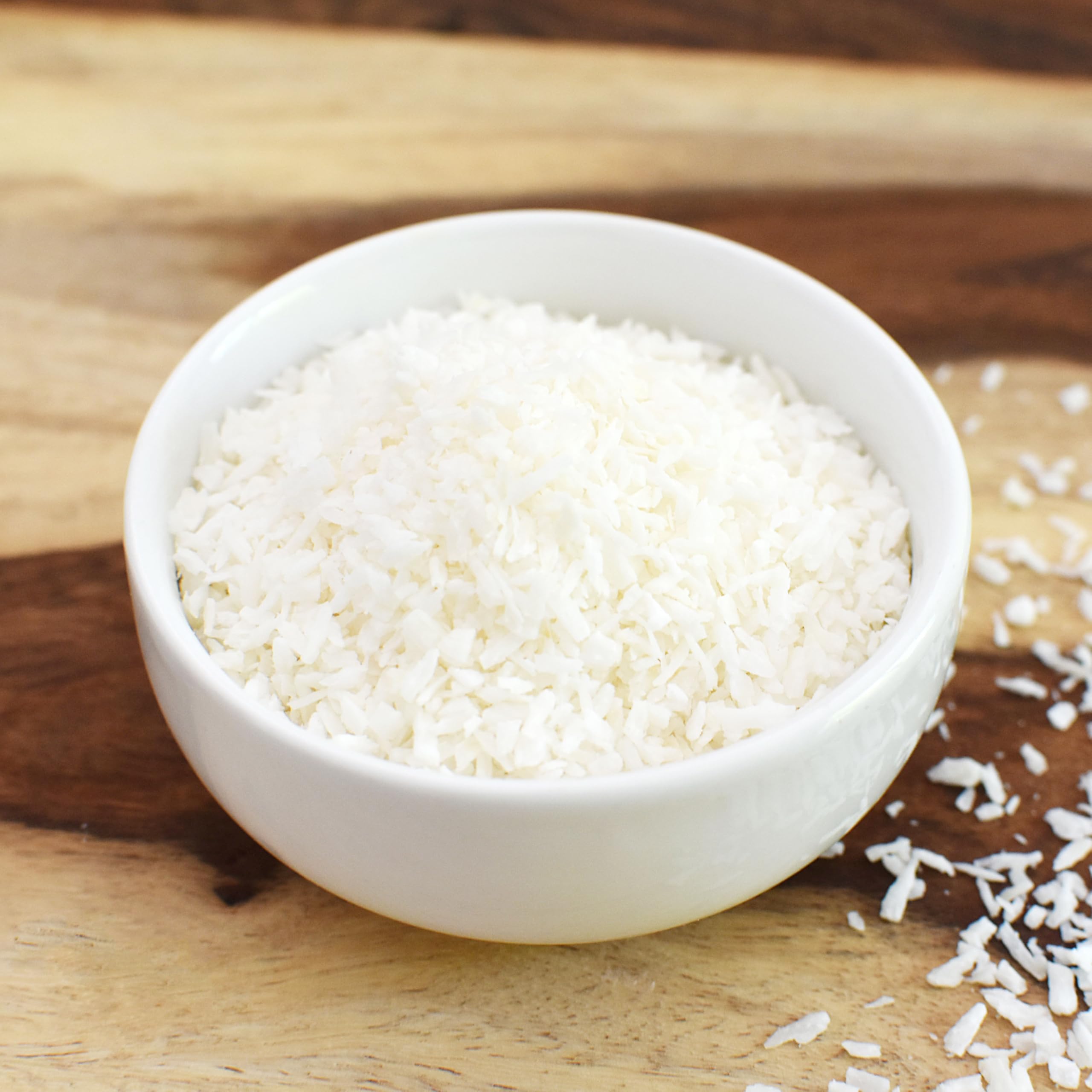 Anthony's 2 lb shredded coconut bag beside measuring cup to show generous supply
