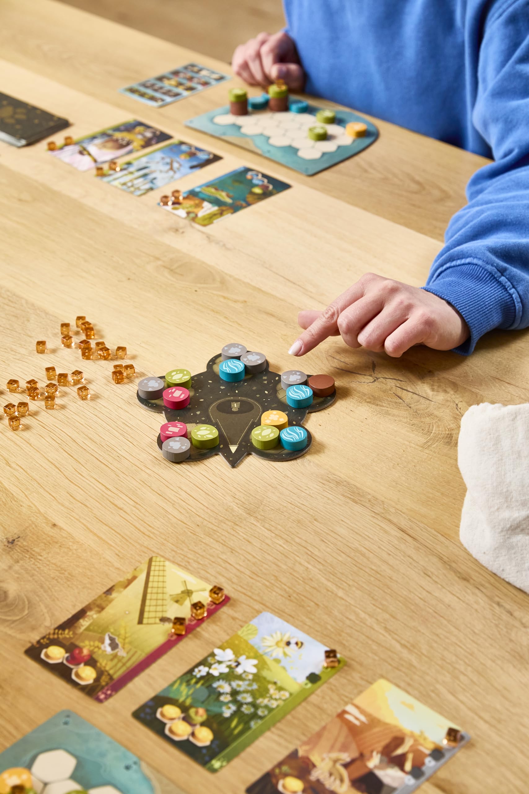 Asmodee game scale with hand showing component size and portability