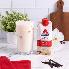 Atkins bottle on table with glass to show meal replacement portion