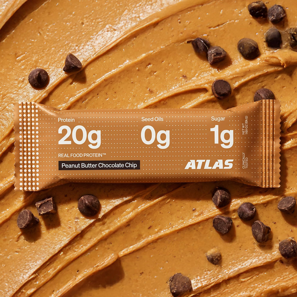 Atlas Protein Bar ingredients spread with roasted peanuts and almonds emphasizing whole-food sourcing