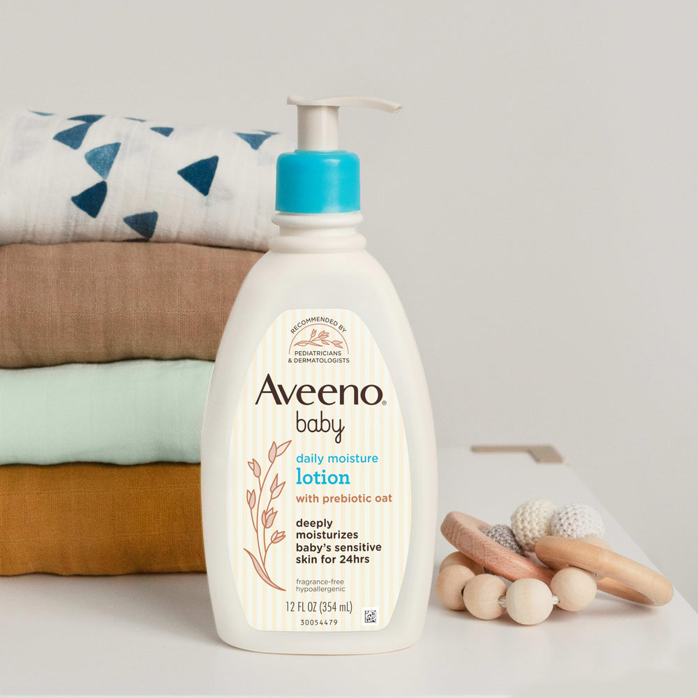 Aveeno Baby size comparison with adult hands to show two 18 fl oz bottles practicality