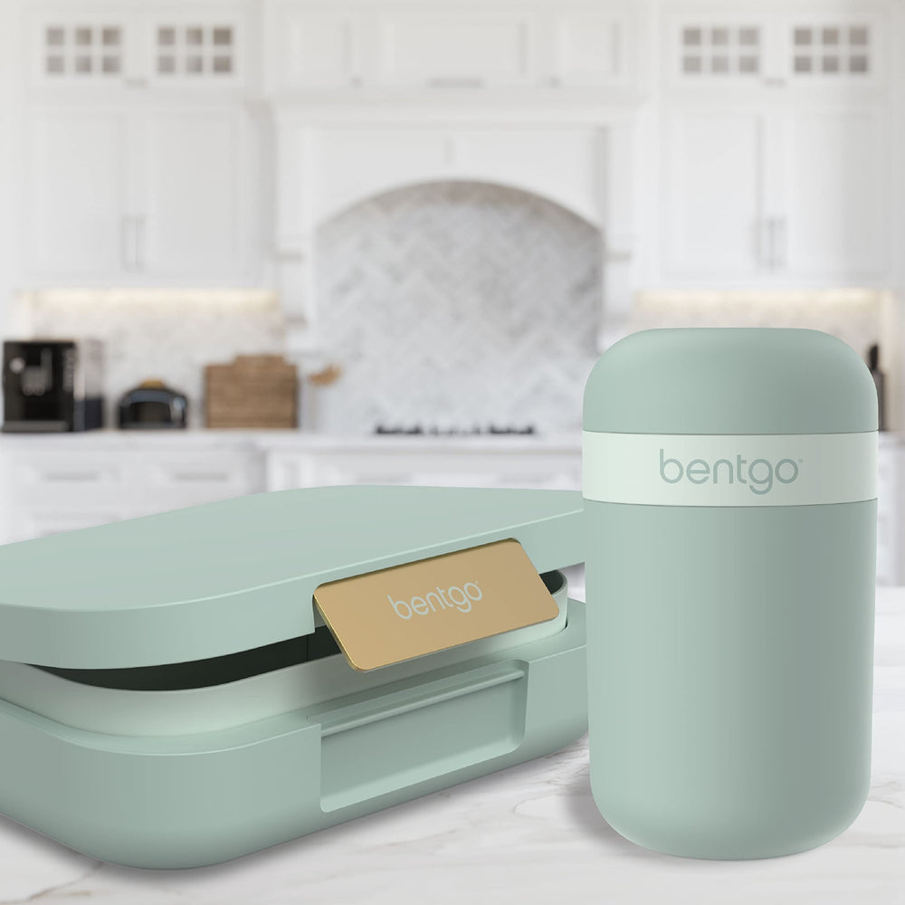 Bentgo snack cup next to hand for scale showing compact capacity