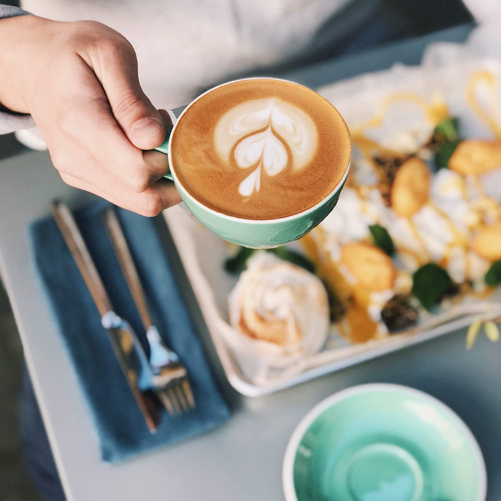 Bestpresso on a breakfast table with cup and croissant, suggests everyday enjoyment