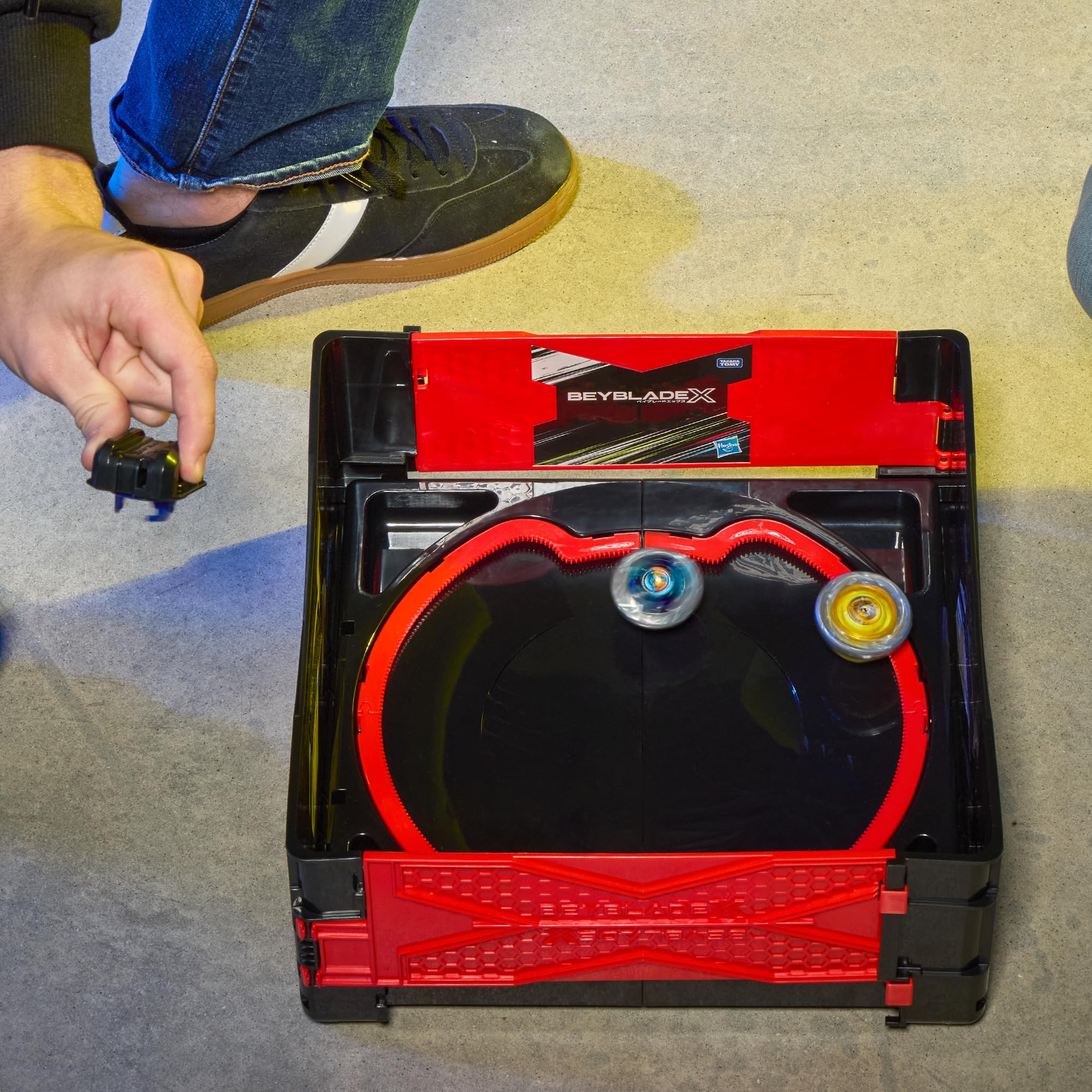 Beyblade stadium next to backpack showing transport convenience