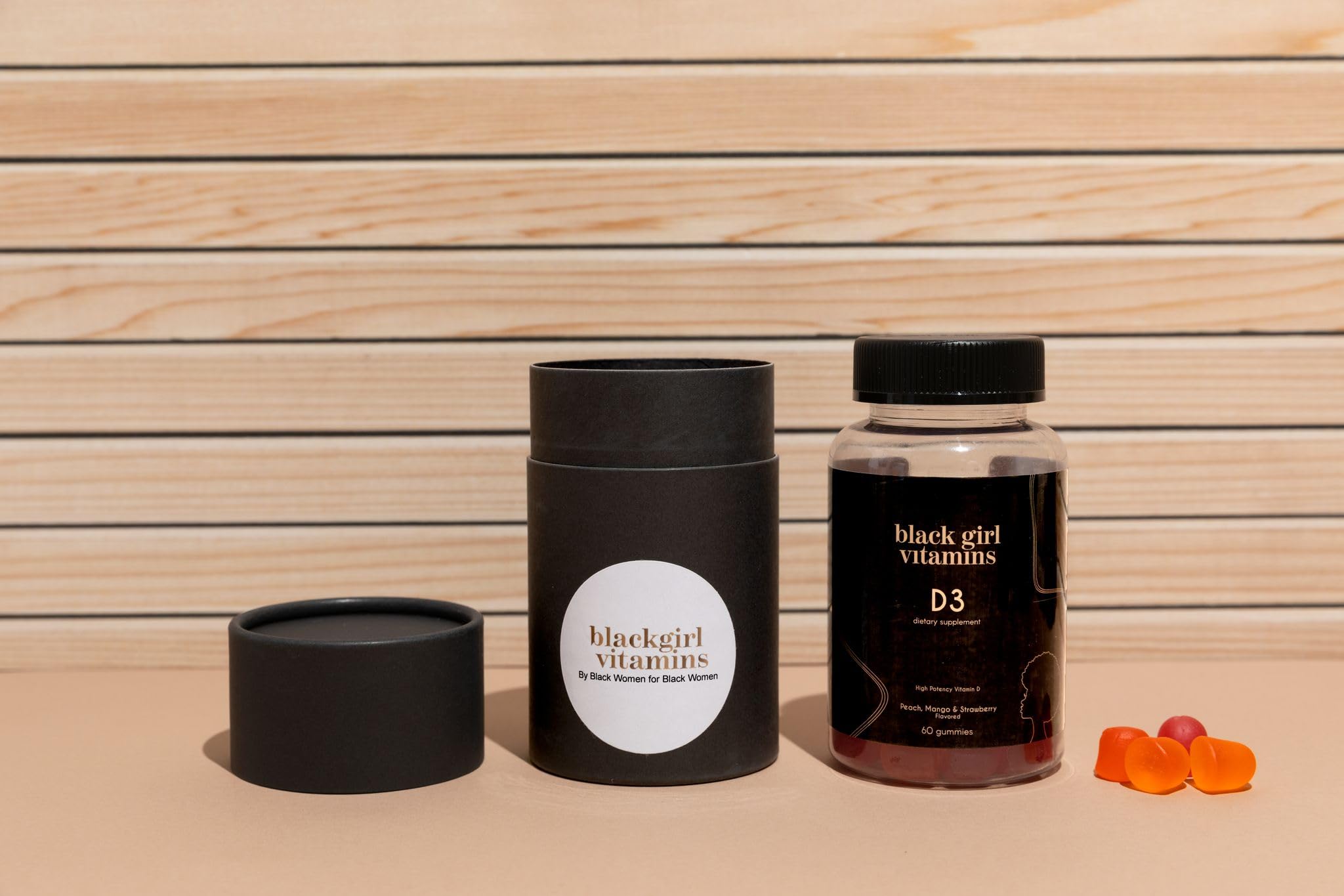 Black Girl Vitamins open bottle with scattered gummies showing flavor appeal