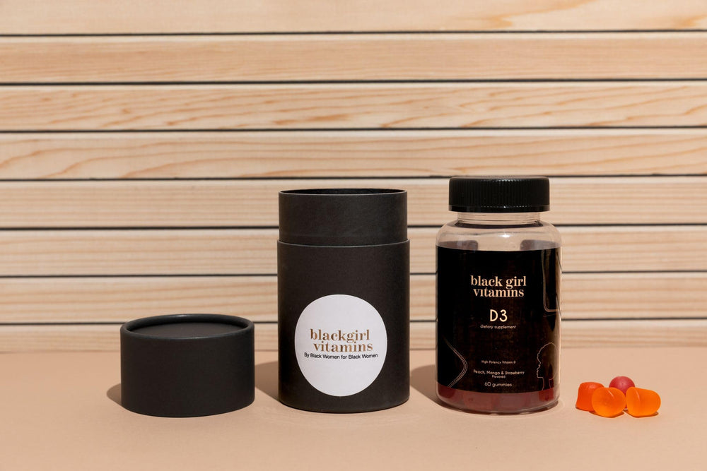 Black Girl Vitamins open bottle with scattered gummies showing flavor appeal