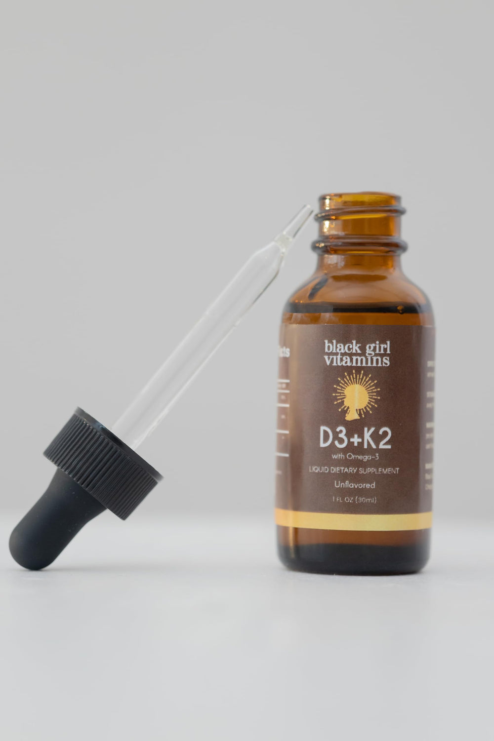 Black Girl Vitamins unflavored drops mixed into a glass illustrating seamless blend and no taste
