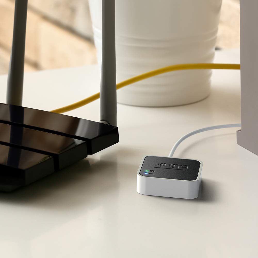 Blink Sync Module 2 placed on shelf with Blink cameras, organizes multi-camera management