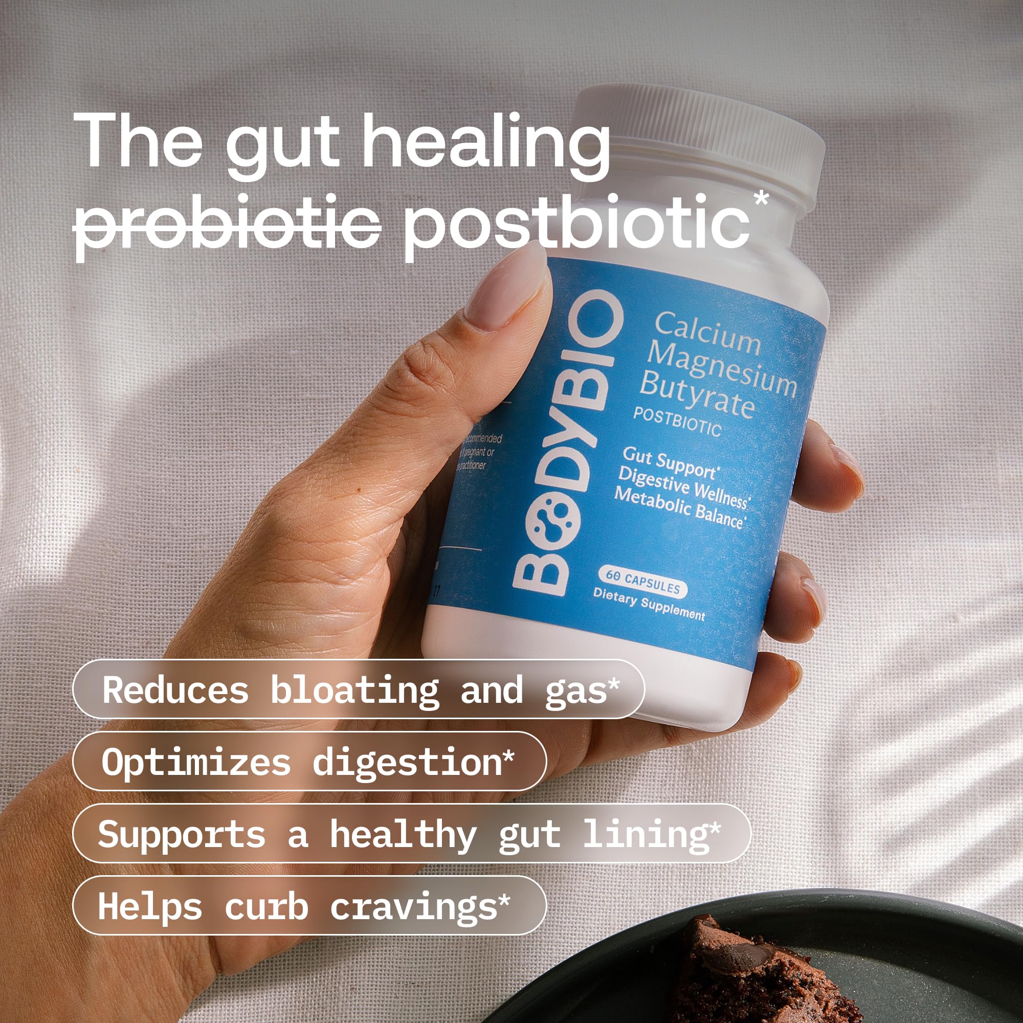 BodyBio capsule in hand providing size reference and convenient daily dosing
