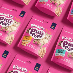 Bonkers Purrpops held in cat paw demonstrating engaging treat interaction