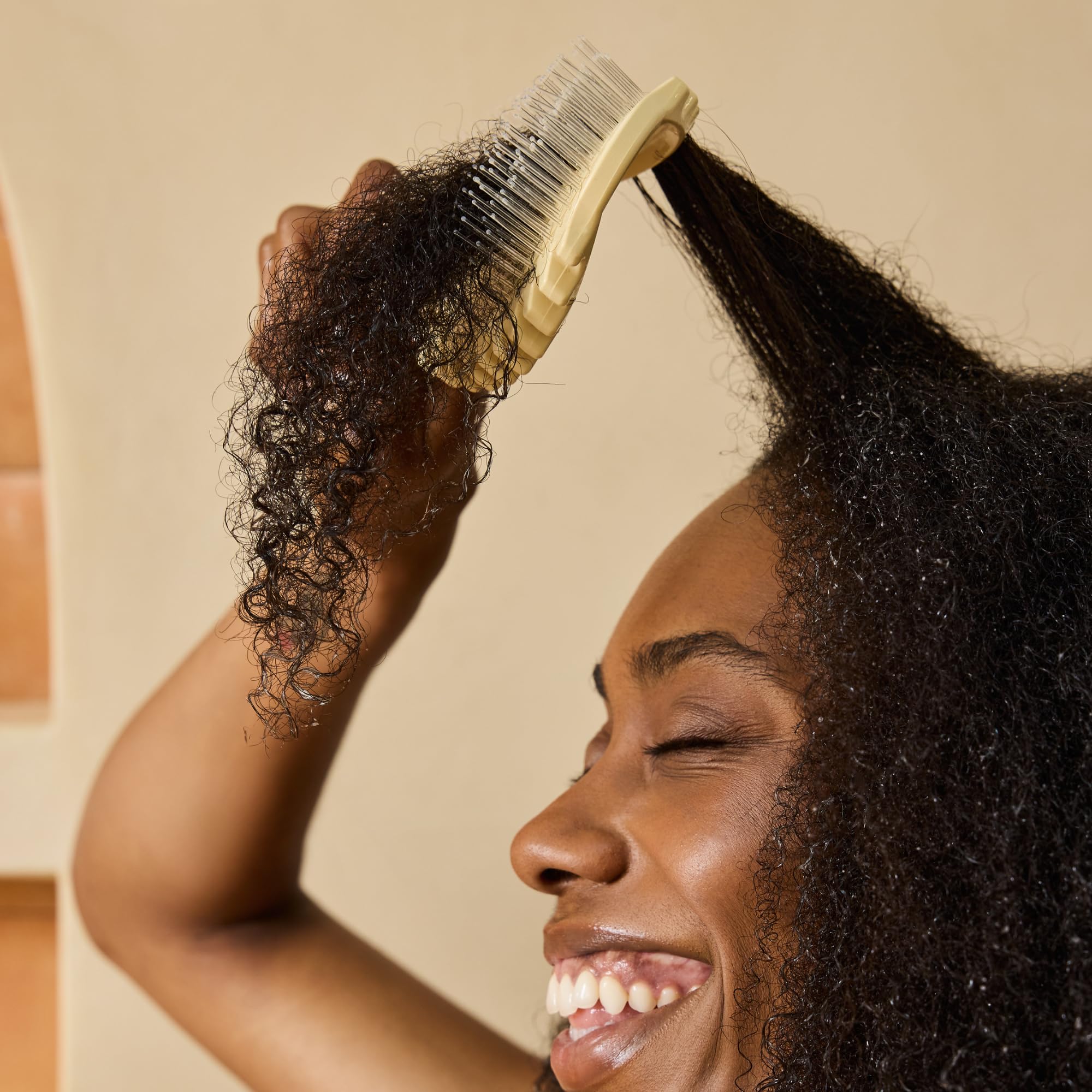 Bounce Curl brush used in shower to detangle and distribute conditioner efficiently