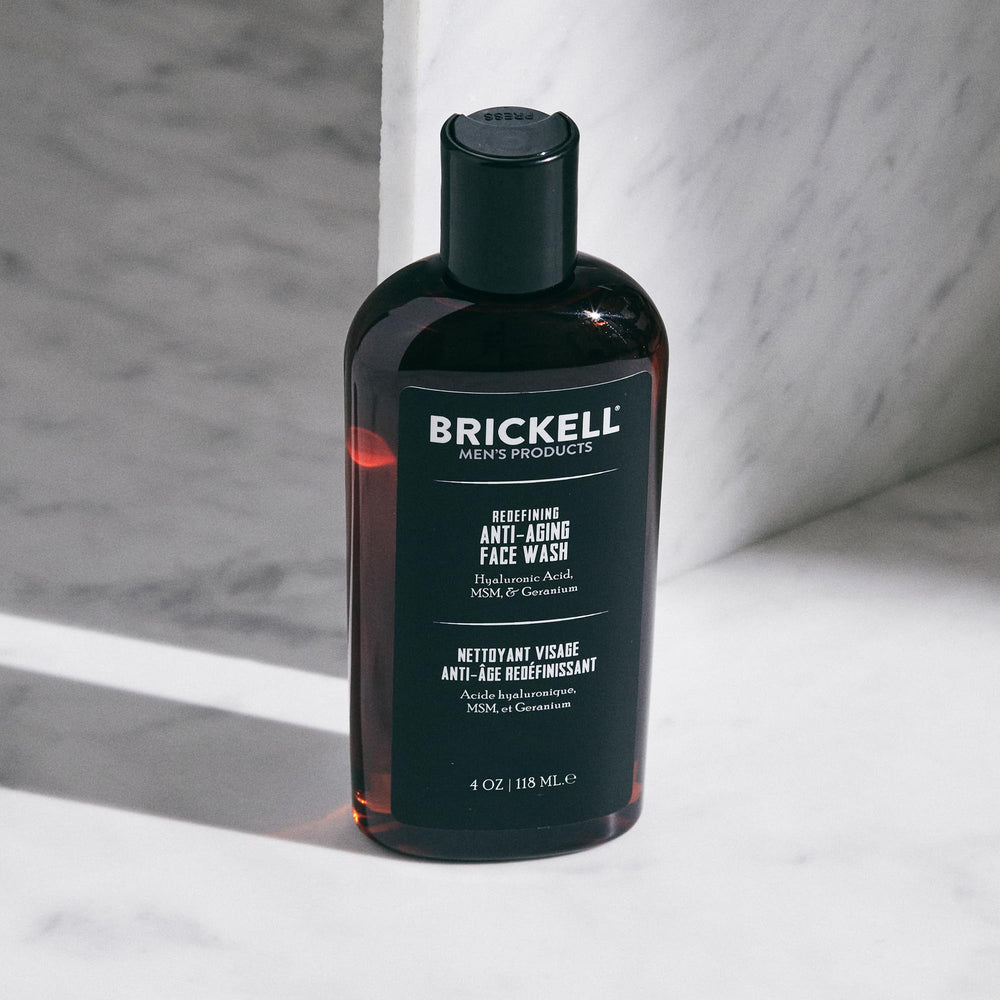Brickell Men's Products 4oz tube next to hand for scale and portability benefit
