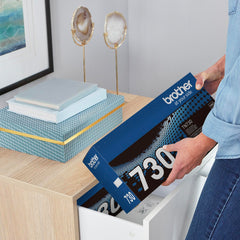 Brother TN-730 next to a letter sheet for scale — clear size and capacity reference