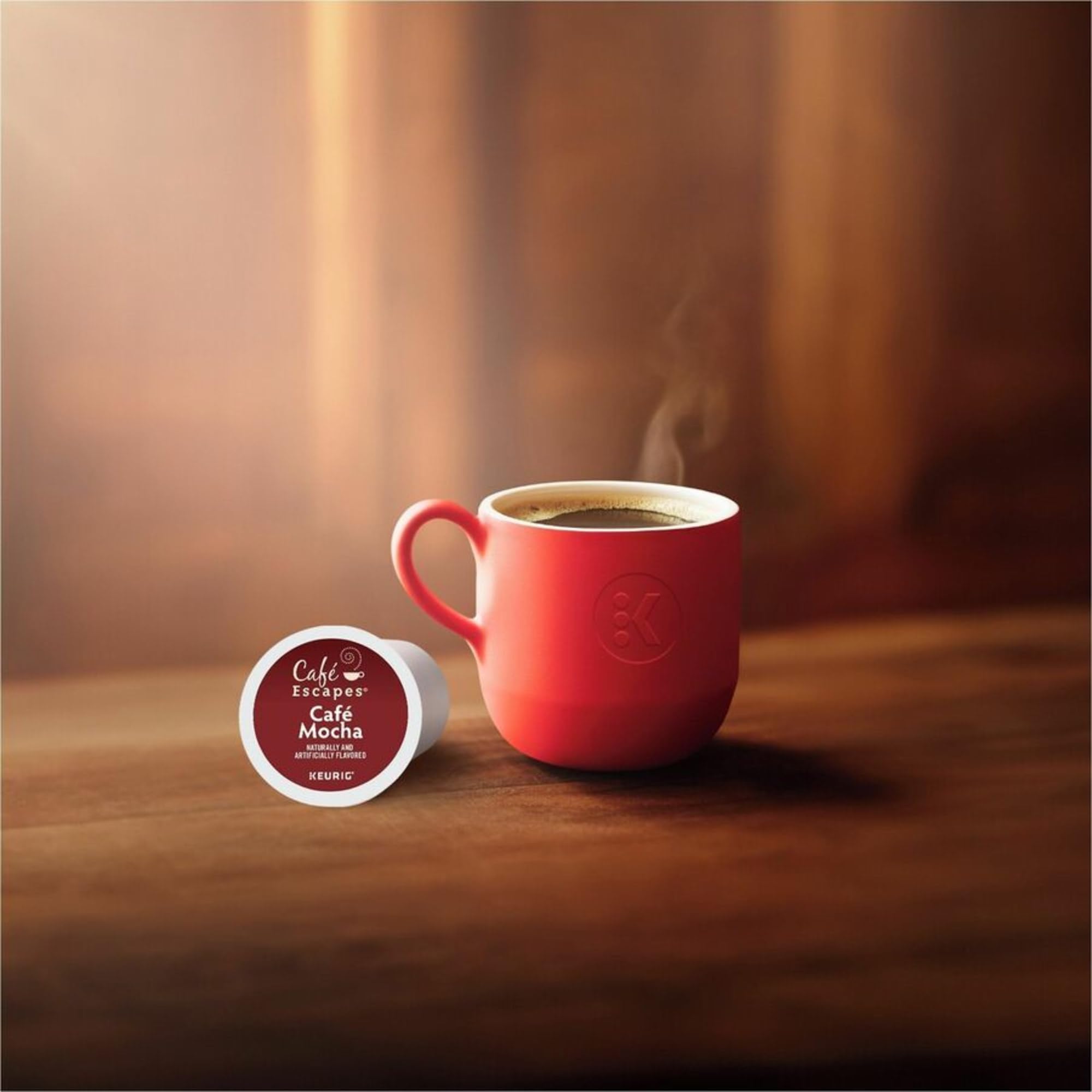 Hand holding Café Escapes pod for size comparison showing convenient portioning