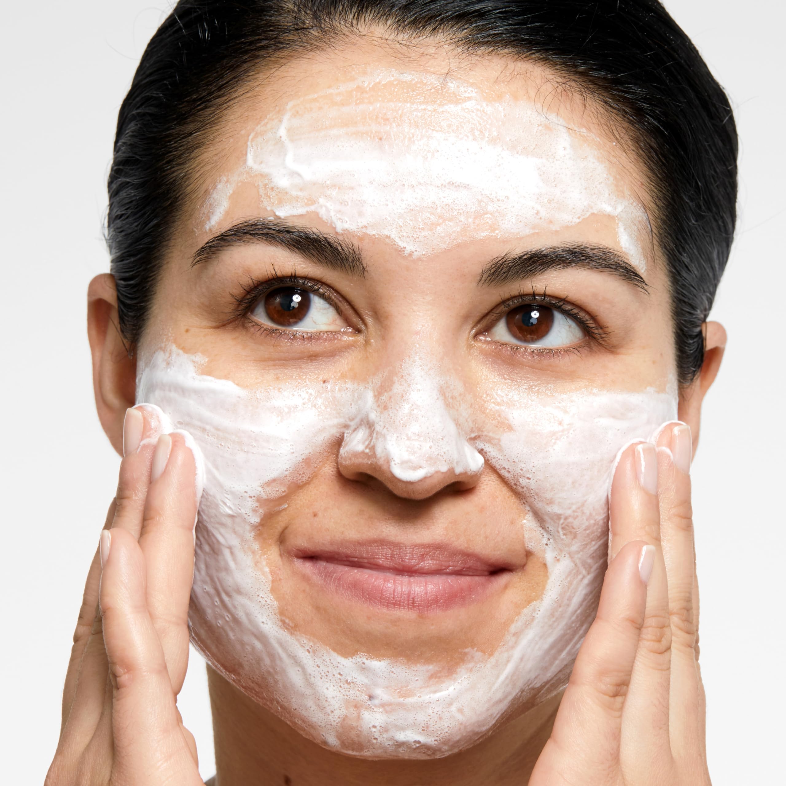 Clinique cleanser in hand showing size and travel-friendly scale benefit