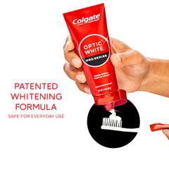 Hand holding Colgate Optic White Pro Series tube for size comparison and travel convenience