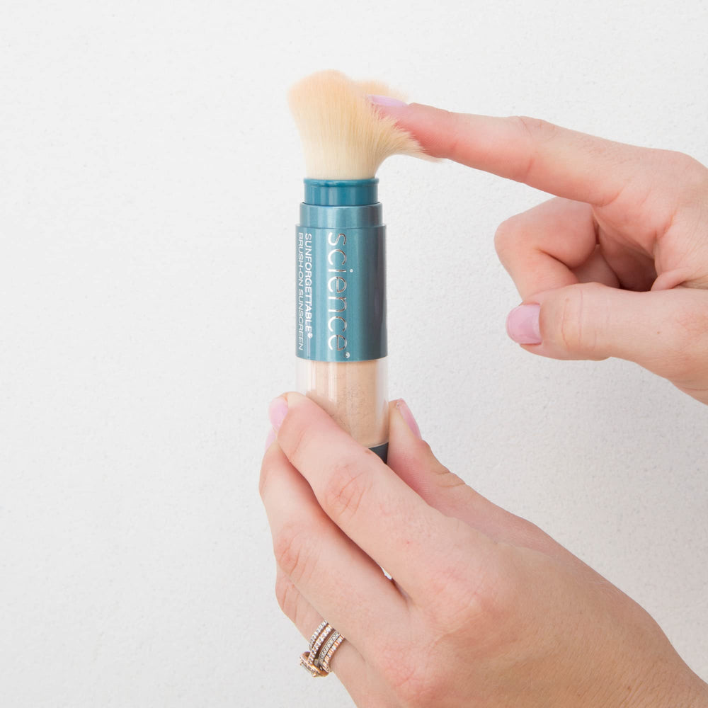 Colorescience brush in hand illustrating travel-friendly size and portability
