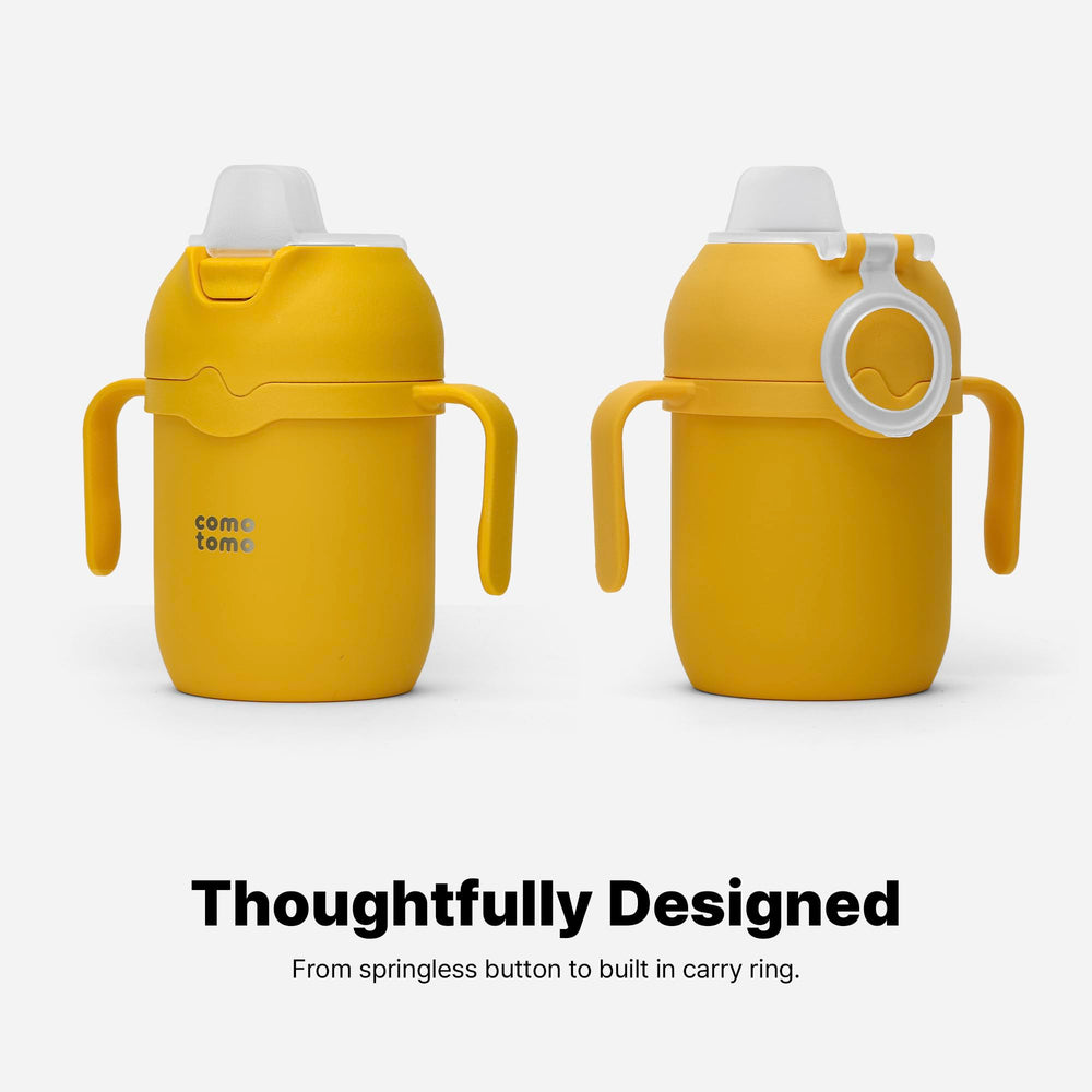 Comotomo tumbler in outdoor stroller cup holder showing leak-resistant travel use advantage