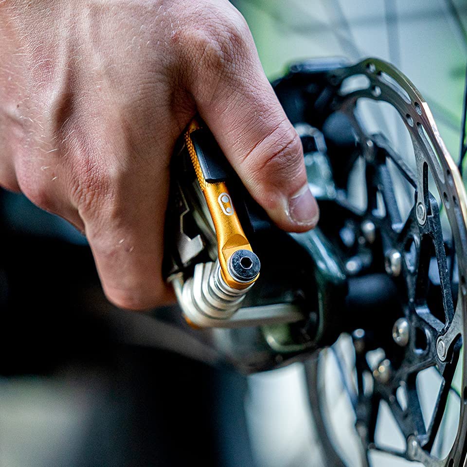 Gloved hand using Crankbrothers Multi Tool demonstrating ergonomic grip for confident trail adjustments benefit safety