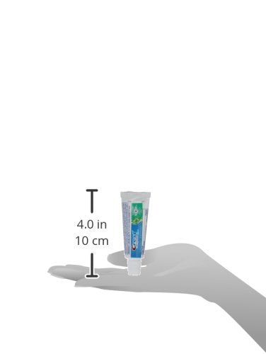 Crest tube next to a credit card showing compact 0.85 oz size for TSA compliance