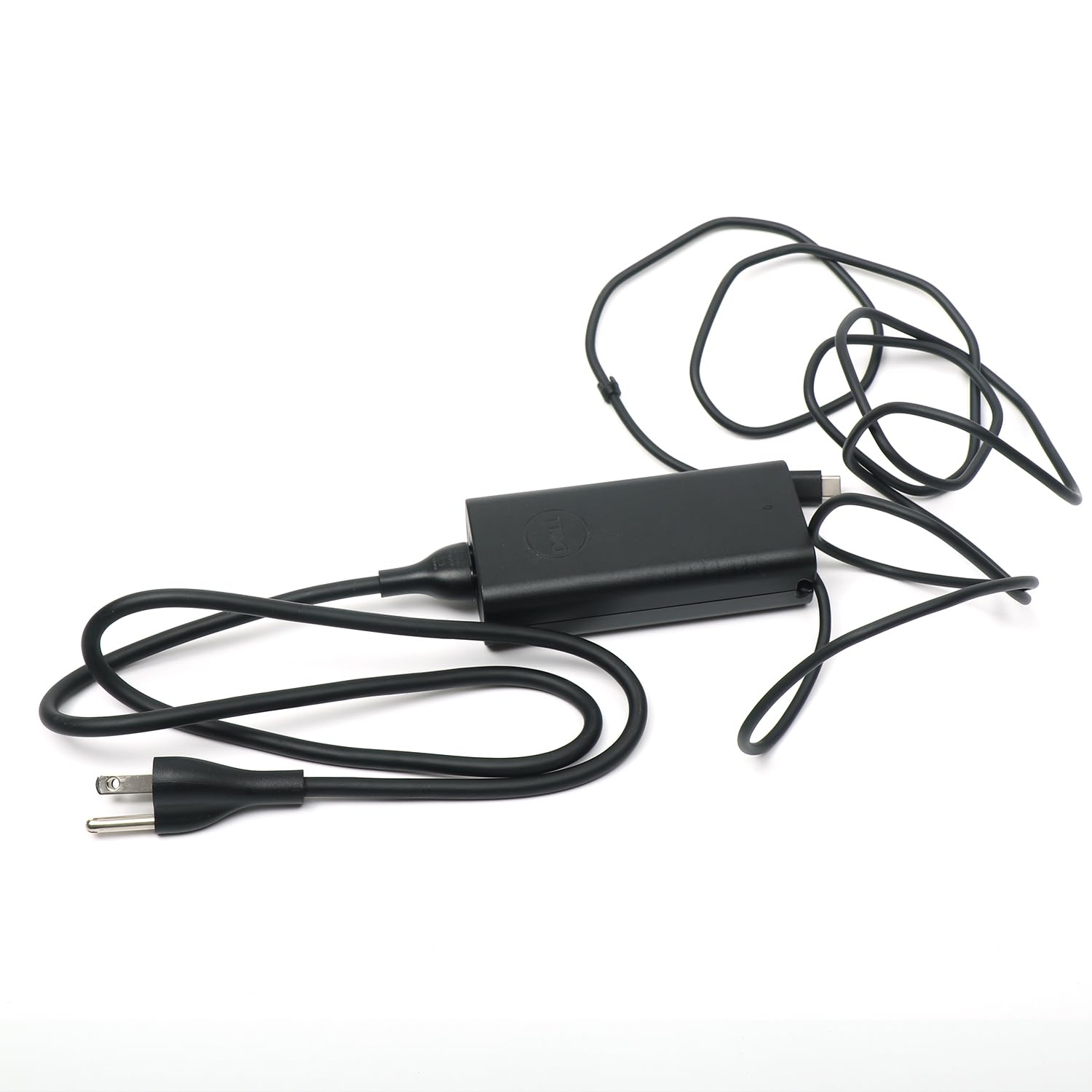 Dell adapter beside a laptop to show compact size and travel convenience