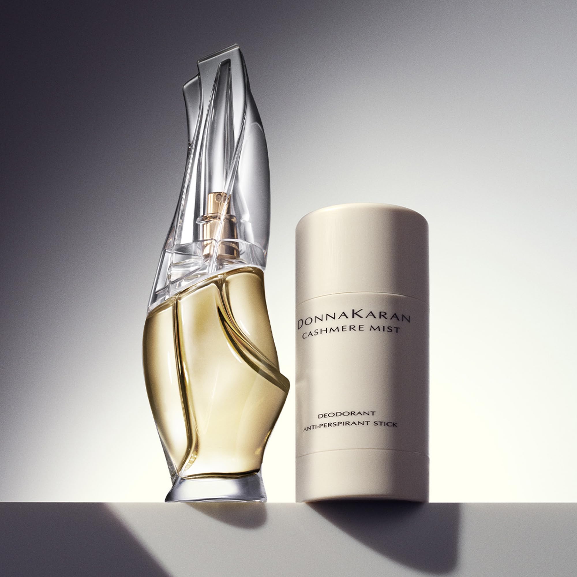 Donna Karan Cashmere Mist next to a passport showing ideal travel-friendly size