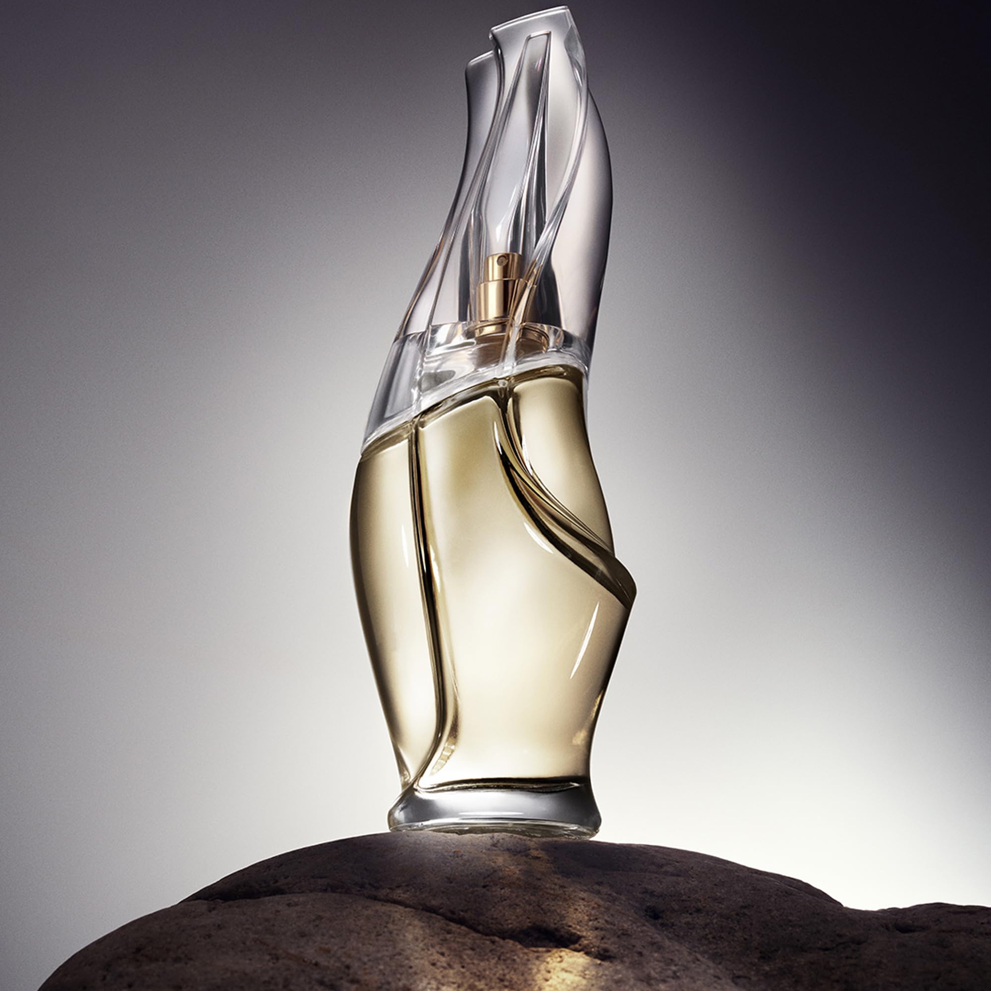 Donna Karan Cashmere Mist spray in hand demonstrating easy on-the-go refresh