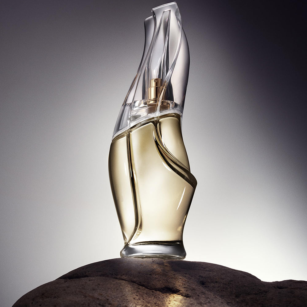 Donna Karan Cashmere Mist spray in hand demonstrating easy on-the-go refresh