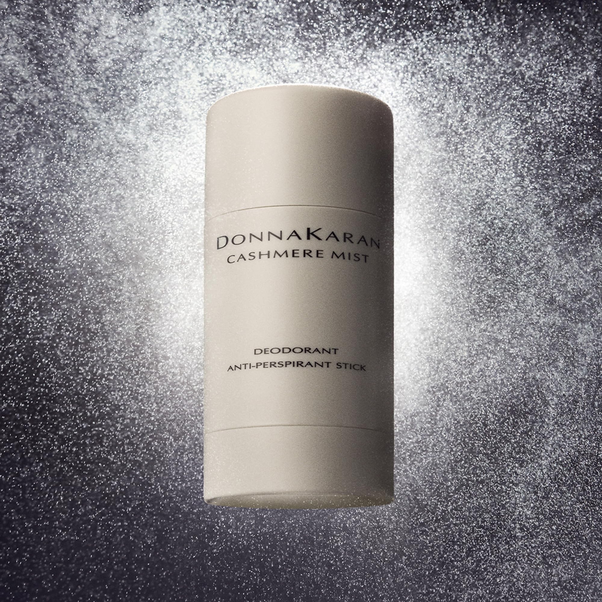 Donna Karan Cashmere Mist stick held in hand to show compact travel size