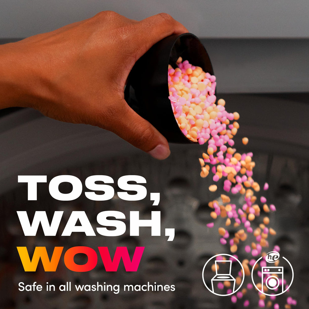 Hand holding handful of Downy Unstopables Fusions beads to show size and dosing control benefit