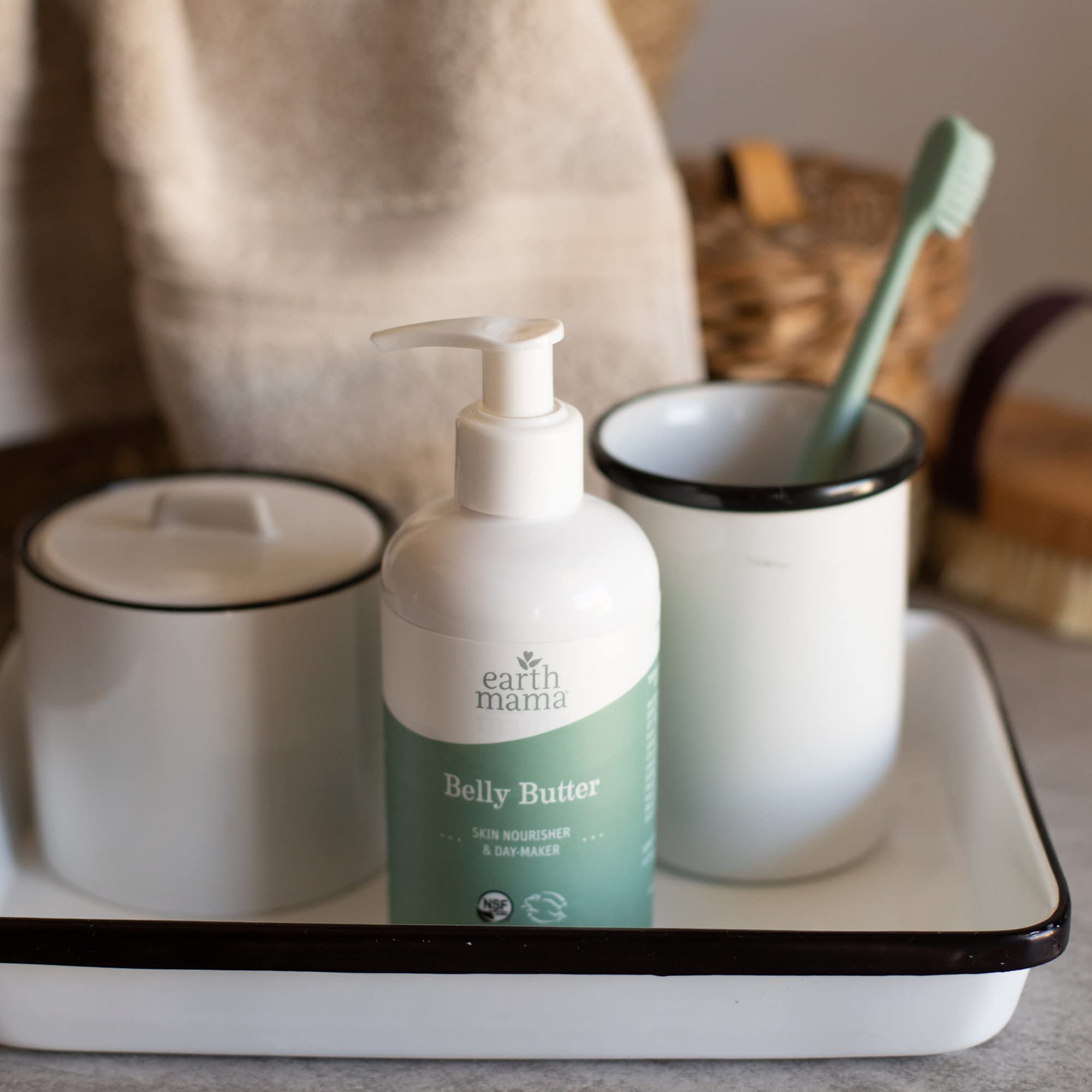 Pregnant person using Earth Mama belly butter in bathroom for calming self-care benefit
