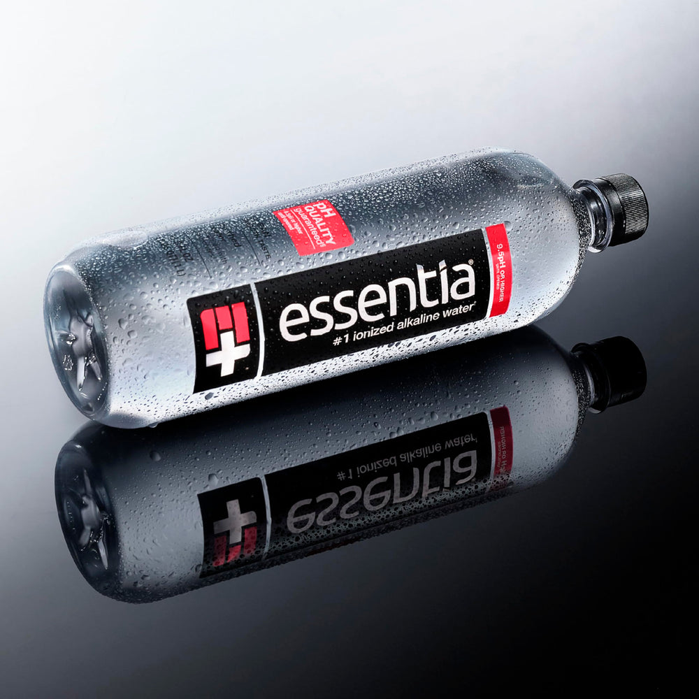 Essentia Water on desk beside laptop showing focused hydration support