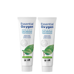 Person brushing with Essential Oxygen toothpaste demonstrating fresh peppermint flavor and whitening effect