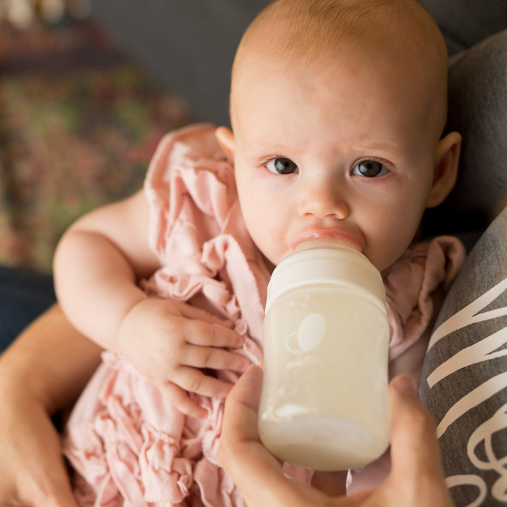 Evenflo bottle in use being held for comfortable paced feeding benefit